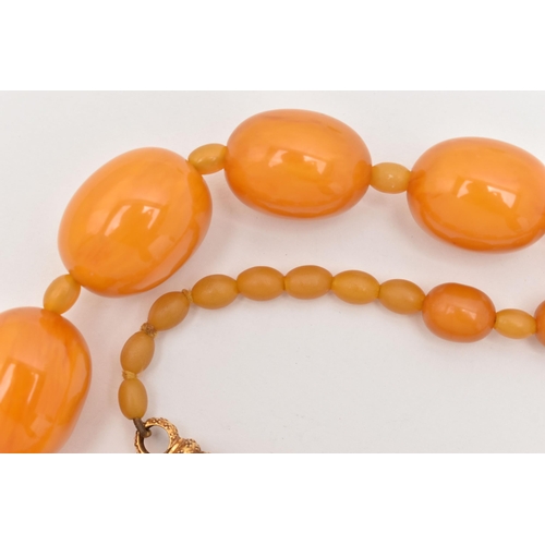 63 - A BAKELITE BEAD NECKLACE, oval orange beads graduating in size with small beads interspaced with sma... 