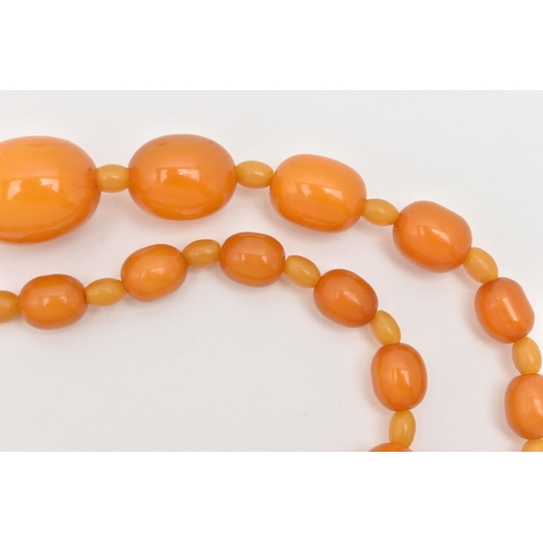 63 - A BAKELITE BEAD NECKLACE, oval orange beads graduating in size with small beads interspaced with sma... 