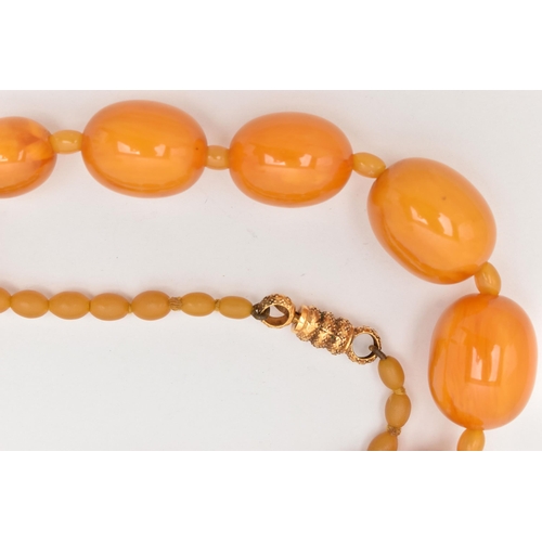 63 - A BAKELITE BEAD NECKLACE, oval orange beads graduating in size with small beads interspaced with sma... 