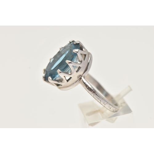 73 - A WHITE METAL BLUE TOPAZ RING, set with a large oval cut blue topaz, measuring approximately length ... 