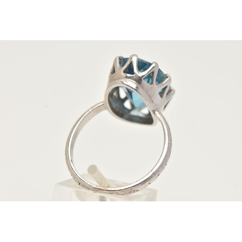 73 - A WHITE METAL BLUE TOPAZ RING, set with a large oval cut blue topaz, measuring approximately length ... 