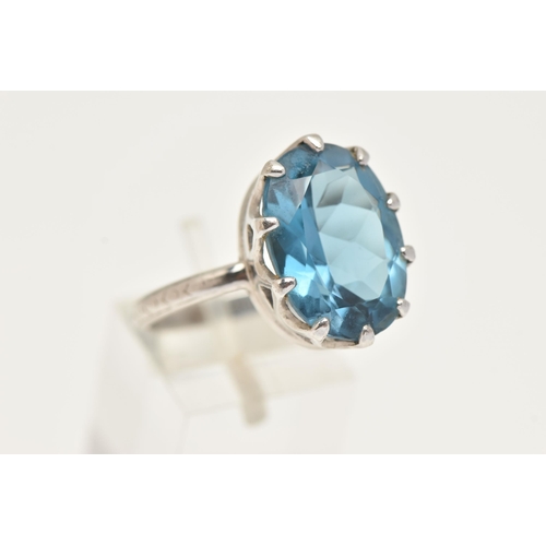 73 - A WHITE METAL BLUE TOPAZ RING, set with a large oval cut blue topaz, measuring approximately length ... 