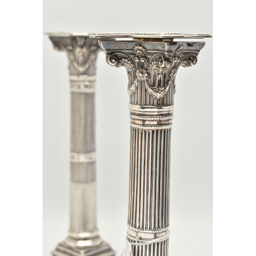 120 - A PAIR OF PRESENTATION CANDLESTICKS, Corinthian columns, scrolling and swag detail beneath the drip ... 