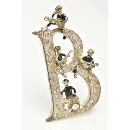 80 - A 'BEATLES' BROOCH,  a large white metal 'B' brooch with four figures playing instruments, signed 'E... 