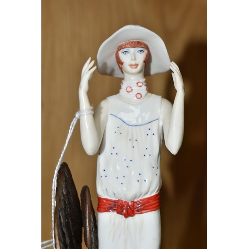 320 - AN ALBANY FINE CHINA ART DECO STYLE FIGURINE, titled Chelsea stood before a bronzed metal stylised t... 