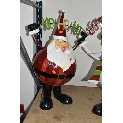 327 - TWO TALL METAL CHRISTMAS DECORATIONS, a metal Santa on a spring mechanism with the words 'HO HO HO',... 