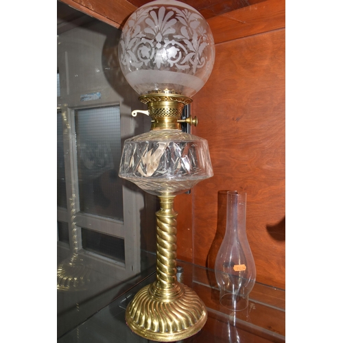 485 - A CUT GLASS AND BRASS OIL LAMP, with cut glass reservoir, brass twist column and base, etched shade ... 