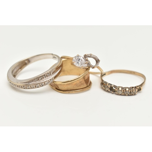 23 - THREE 9CT GOLD RINGS AND A YELLOW METAL RING, the first a white gold diamond set cross over ring, ha... 