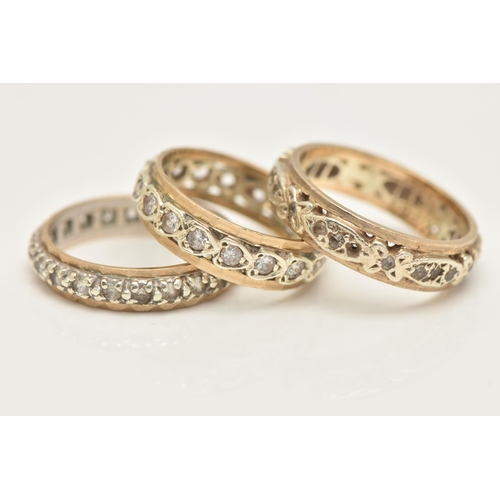 27 - THREE YELLOW METAL FULL SET ETERNITY BAND RINGS, each set with colourless spinel's, one stamped 9.37... 