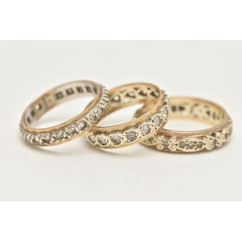 27 - THREE YELLOW METAL FULL SET ETERNITY BAND RINGS, each set with colourless spinel's, one stamped 9.37... 