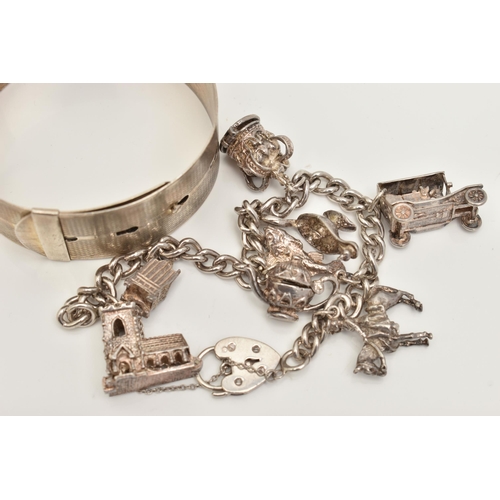 81 - A WHITE METAL CHARM BRACELET AND BANGLE, the charm bracelet suspending eight charms from a curb link... 