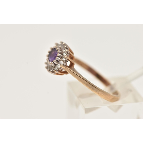 84 - A 9CT YELLOW GOLD AMETHYST CLUSTER RING, of an oval form, set to the centre with an oval cut amethys... 