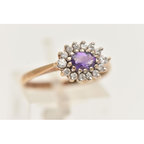 84 - A 9CT YELLOW GOLD AMETHYST CLUSTER RING, of an oval form, set to the centre with an oval cut amethys... 