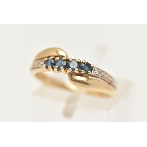 89 - A 9CT GOLD GEM SET RING, of a cross over design, set with a row of four circular cut deep blue sapph... 