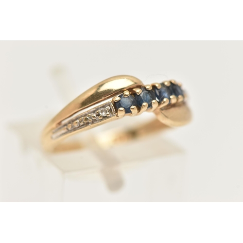 89 - A 9CT GOLD GEM SET RING, of a cross over design, set with a row of four circular cut deep blue sapph... 