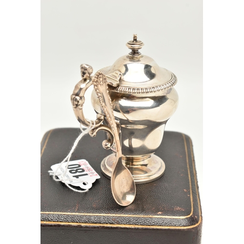180 - A CASED LATE VICTORIAN SILVER MUSTARD WITH SPOON, urn shape mustard fitted with a scrolling handle a... 