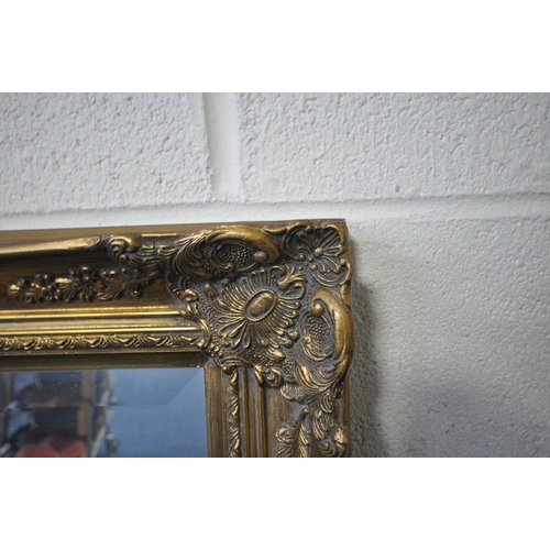 1202 - A LARGE RECTANGULAR GILT FRAME BEVELLED EDGE WALL MIRROR, with foliate decorations, 133cm x 107cm (c... 