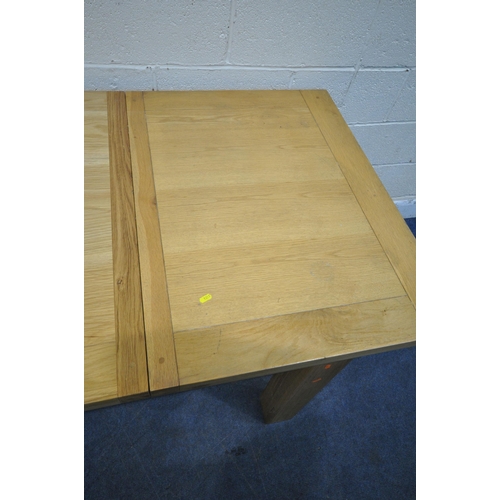 1215 - A MODERN SOLID OAK RECTANGULAR EXTENDING DINING TABLE, raised on block legs, with two leaves, extend... 