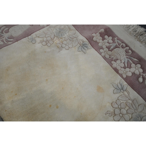 1216 - A CREAM GROUND RECTANGULAR CHINESE WOOLEN RUG, with foliate design, and a border, 200cm x 122cm, alo... 