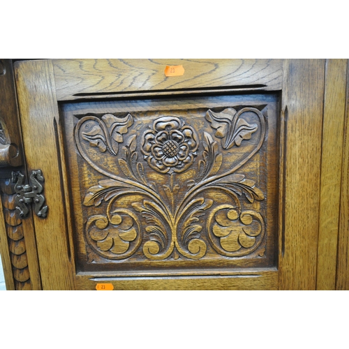 1225 - A 20TH CENTURY SOLID OAK FOUR DOOR CUPBOARD, each door with two panels depicting the Tudor rose, abo... 