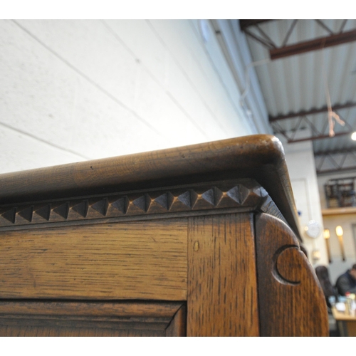 1225 - A 20TH CENTURY SOLID OAK FOUR DOOR CUPBOARD, each door with two panels depicting the Tudor rose, abo... 