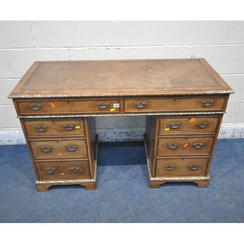 1227 - AN EDWARDIAN WALNUT TWIN PEDESTAL DESK, with a leather writing surface, fitted with eight assorted d... 