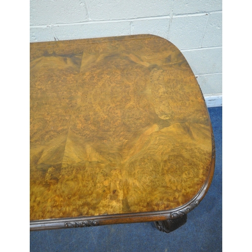 1231 - A 20TH CENTURY BURR WALNUT TABLE, with rounded ends, raised on four scrolled legs, with bun feet, un... 