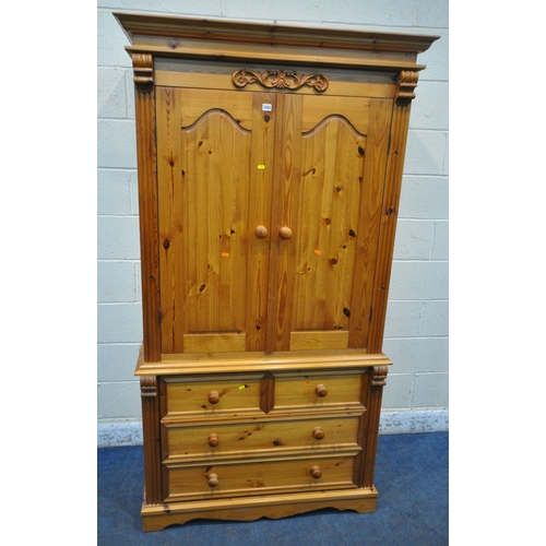 1243 - A MODERN PINE WARDROBE, with double cupboard doors, atop a base with two short over two long drawers... 