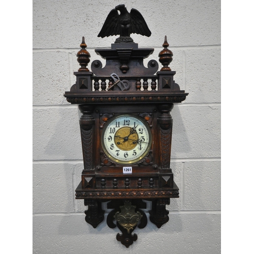 1261 - A 20TH CENTURY OAK WALL CLOCK, eagle pediment, flanked by twin finials, the door enclosing a 7 inch ... 