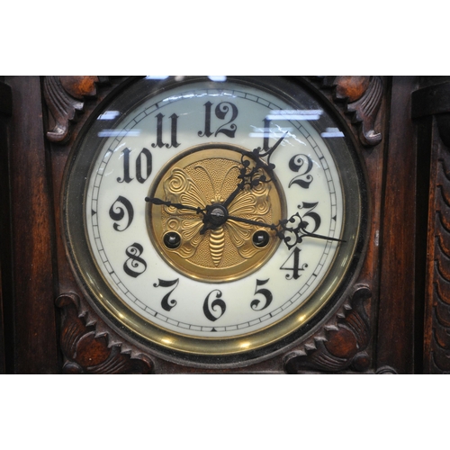 1261 - A 20TH CENTURY OAK WALL CLOCK, eagle pediment, flanked by twin finials, the door enclosing a 7 inch ... 