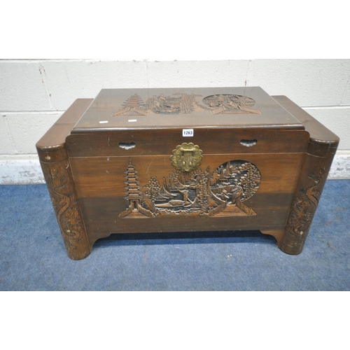 1263 - AN ORIENTAL CAMPHORWOOD CHEST, the hinged lid enclosing a removable tray, the top and front with car... 