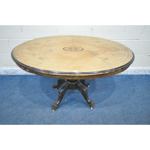 1267 - A 19TH CENTURY WALNUT TILT TOP OVAL LOO TABLE, with marquetry inlay to centre, raised on a turned su... 