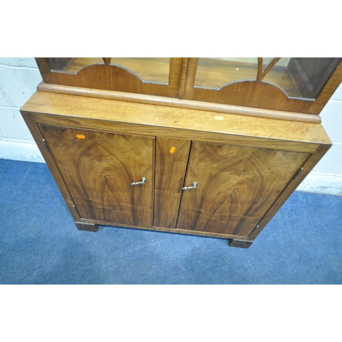 1308 - A 20TH CENTURY BOOKCASE, with double glazed doors, atop a base with double cupboard doors, width 89c... 