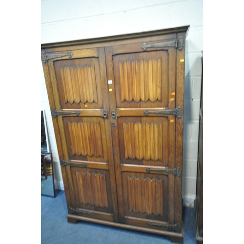 1321 - A 20TH CENTURY OAK TWO PIECE BEDROOM SUITE, comprising two sized linenfold double door wardrobes, la... 