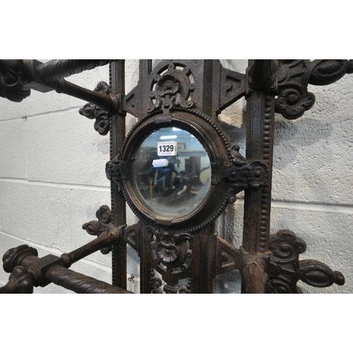 1329 - A VICTORIAN CAST IRON HALL STAND, with an arrangement of rails and pegs, a small circular mirror, re... 