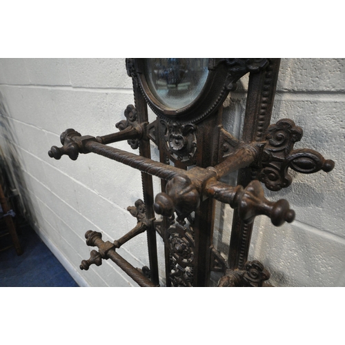 1329 - A VICTORIAN CAST IRON HALL STAND, with an arrangement of rails and pegs, a small circular mirror, re... 