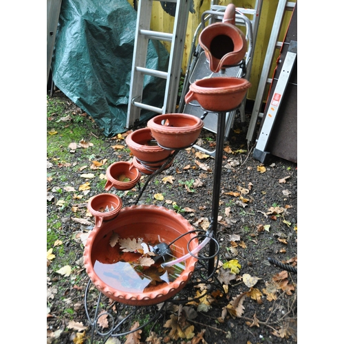 1012 - A MODERN WROUGHT IRON AND EARTHENWARE GARDEN WATER FEATURE in the form of a series of jug and bowls ... 