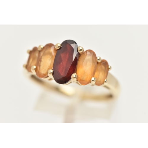 21 - A 9CT GOLD GEM SET RING, an oval cut garnet and four oval cut citrines, prong set in yellow gold, ha... 