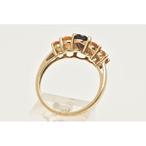 21 - A 9CT GOLD GEM SET RING, an oval cut garnet and four oval cut citrines, prong set in yellow gold, ha... 