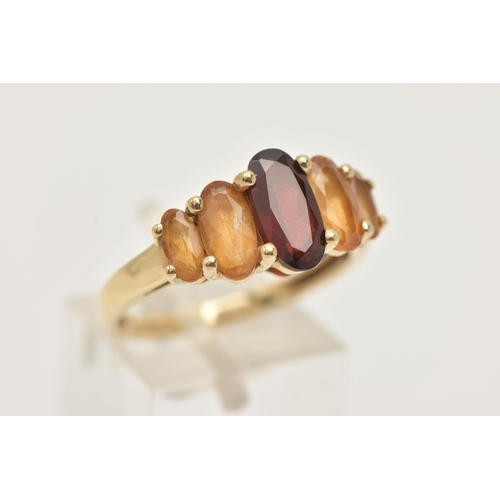 21 - A 9CT GOLD GEM SET RING, an oval cut garnet and four oval cut citrines, prong set in yellow gold, ha... 