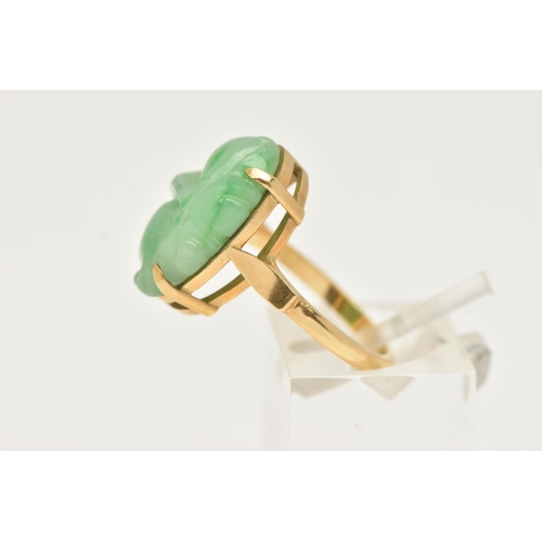 3 - A CARVED JADE RING, oval carved green jade, prong set in yellow metal, approximate length 18mm, yell... 