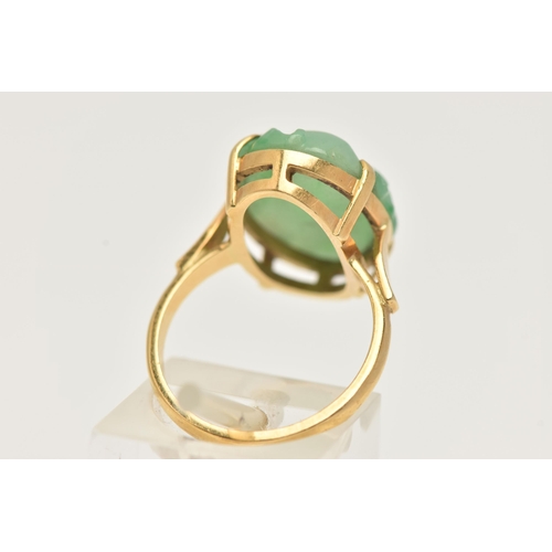 3 - A CARVED JADE RING, oval carved green jade, prong set in yellow metal, approximate length 18mm, yell... 