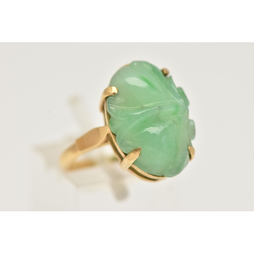 3 - A CARVED JADE RING, oval carved green jade, prong set in yellow metal, approximate length 18mm, yell... 