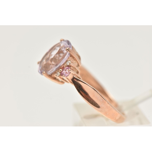 41 - A 9CT GOLD GEM SET RING, an oval cut pink stone, flanked with four round brilliant cut diamonds and ... 