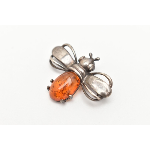 84 - A WHITE METAL AND AMBER BEE BROOCH, set with an amber cabochon body, unmarked metal, fitted with a b... 