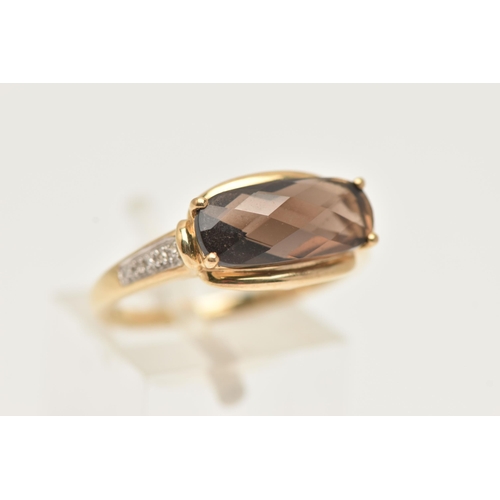 9 - A YELLOW METAL GEM SET RING, a faceted oblong smoky quartz, flanked with four single cut diamonds, y... 