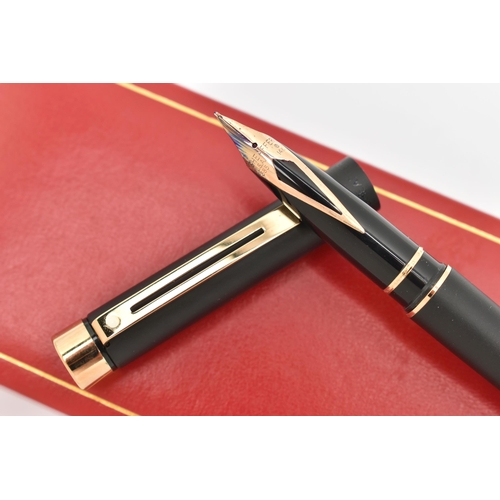 100 - A 'SHEAFFER' FOUNTAIN PEN, a black cased pen signed 'Sheaffer', fitted with a yellow metal nib, stam... 