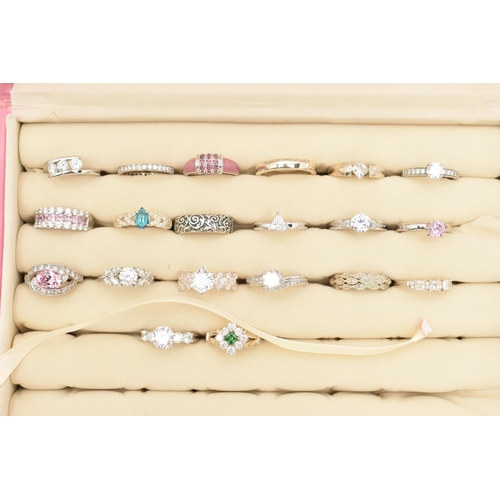 135 - A PINK RING STORAGE BOX WITH TWENTY WHITE METAL RINGS, of various designs, most set with cubic zirco... 