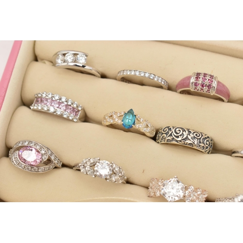 135 - A PINK RING STORAGE BOX WITH TWENTY WHITE METAL RINGS, of various designs, most set with cubic zirco... 