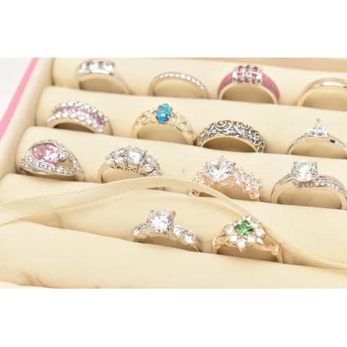 135 - A PINK RING STORAGE BOX WITH TWENTY WHITE METAL RINGS, of various designs, most set with cubic zirco... 